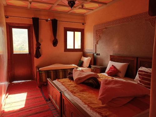 伊姆利尔Riad Atlas Sultana的一间卧室配有两张床和镜子
