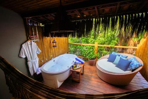 皮帕Xamã Senses - Hotel Pousada的带浴缸和浴缸的浴室。