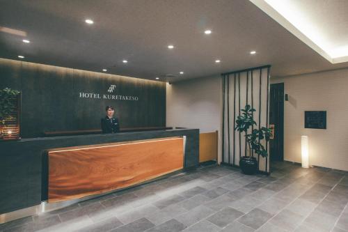 高山Hotel Kuretakeso Takayama Ekimae的一个人站在酒店大厅的前台