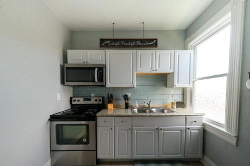 汉密尔顿Robin's Nest - Miami U, Weddings or Spooky Nook!的厨房配有白色橱柜、水槽和炉灶。