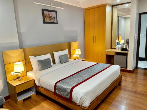 勒克瑙Hotel Sarvin的一间卧室配有一张大床和两盏灯。