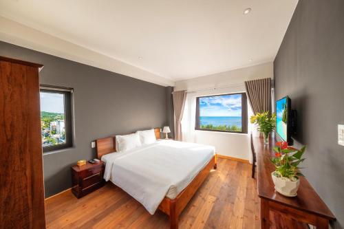 富国富国克盖亚酒店的卧室配有白色的床和2扇窗户。
