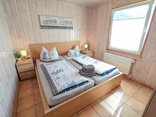 奥斯赛拜-塞林Ferienhaus Sellin的一间卧室配有带2个床头柜和1扇窗户的床