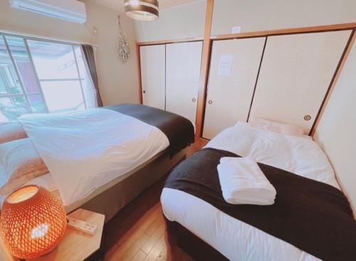 伊势市Minpaku inn Ise-Shima - Vacation STAY 39102v的小房间设有两张床和一张桌子