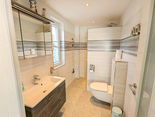 奥斯赛拜-塞林Ferienhaus Sellin的浴室配有盥洗盆、卫生间和浴缸。