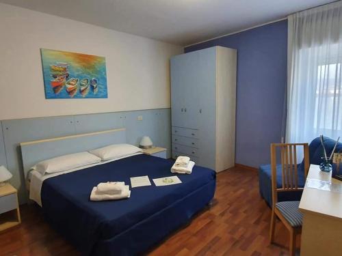 穆贾布索拉酒店的一间卧室配有蓝色的床和一张桌子及椅子