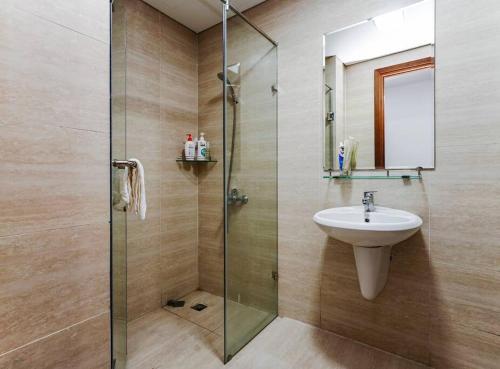 下龙湾*Ha Long Homestay @ Sunrise Apartment- 4 BR的一间带水槽和玻璃淋浴的浴室