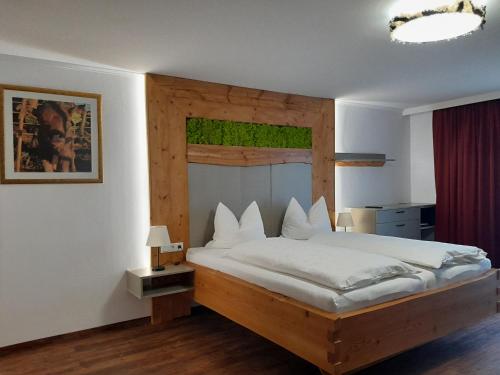 阿特湖Gasthofladen Schneeweiss的一间卧室配有一张大床和木制床头板