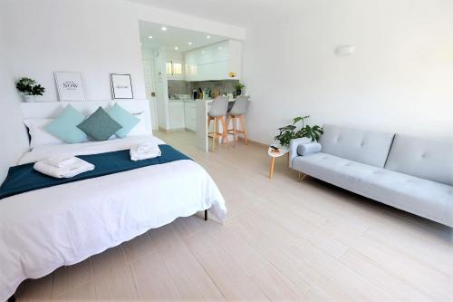 贝纳尔马德纳Benalmadena Jupiter - SunSea Apartments的白色卧室设有一张大床和一张沙发