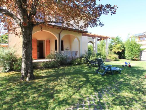 马尔米堡Villa Villa Gino by Interhome的院子中有一棵树和长凳的房子