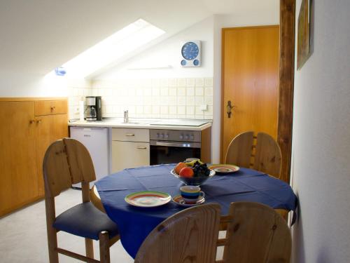 莱希布鲁克Apartment Fischer by Interhome的厨房配有一张桌子,上面有蓝色的桌布