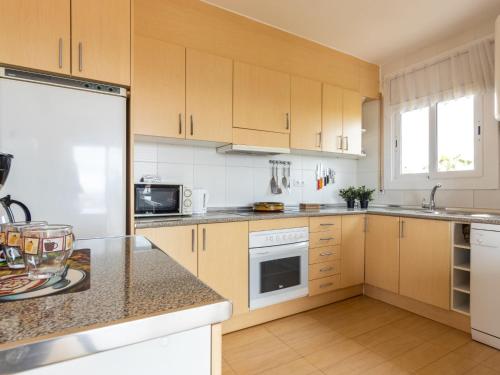 托里代巴拉Apartment Regina by Interhome的厨房配有白色家电和木制橱柜