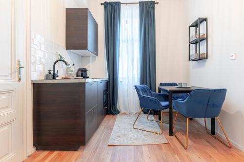 圣珀尔滕City Appartement WAGRAM am Hauptbahnhof的厨房配有桌子和2把蓝色椅子