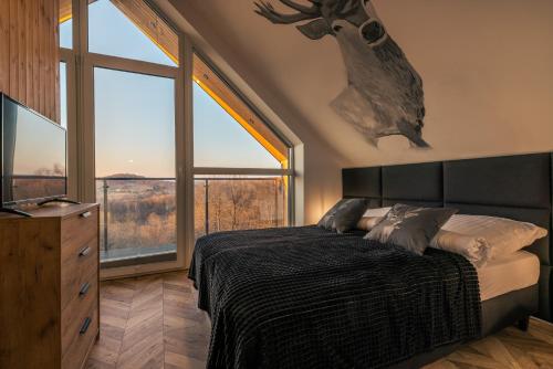 索利纳Jaworowe Wzgórze Solina的一间卧室设有一张床和一个大窗户