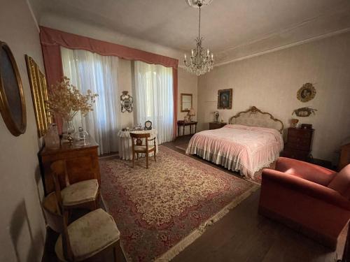 佛罗伦萨CASA LA TORRE un castello alle porte di Firenze的一间卧室配有一张床、一把椅子和一张桌子