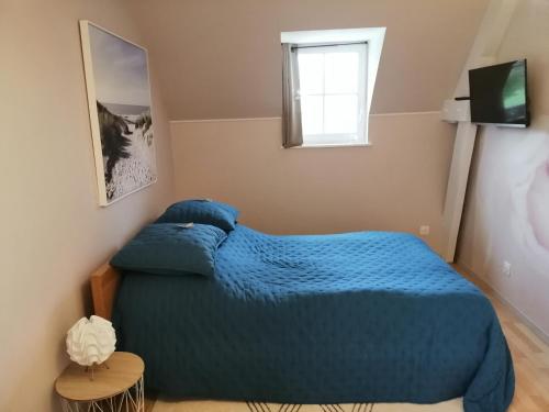 GranguesLe Torcopel的一间卧室设有蓝色的床和窗户。