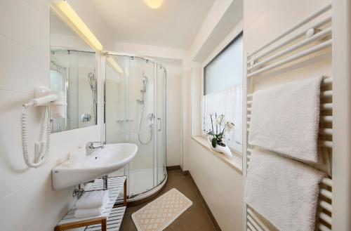拉古多Pension Siller的白色的浴室设有水槽和淋浴。