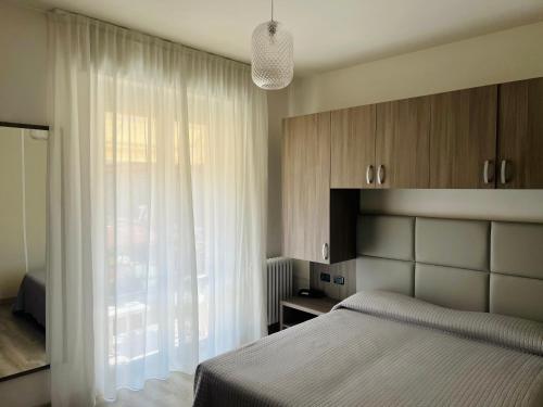 巴多利诺卡马萨瓦尔撒酒店的一间卧室设有一张床和一个大窗户