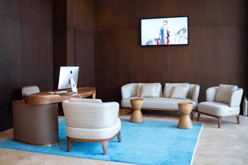 奇姆肯特Pana Boutique Hotel的客厅配有家具和墙上的电视