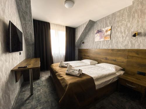 赫拉布斯Hotel Petra的一间卧室配有一张床、一张书桌和一台电视