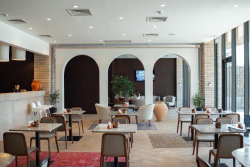 奇姆肯特Pana Boutique Hotel的餐厅设有桌椅和窗户。