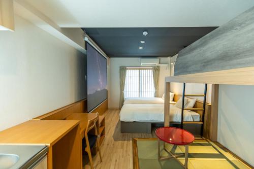 大阪Minn Shin-Osaka的小房间设有一张床和一张书桌