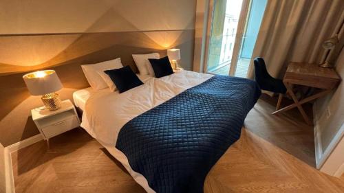 华沙Apartament Powiśle Deluxe的一间卧室配有一张带蓝色毯子的大床