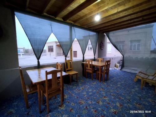 希瓦Naqqosh的用餐室配有木桌和椅子