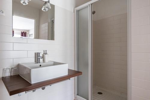 康卡勒Gîte Taumain的白色的浴室设有水槽和淋浴。