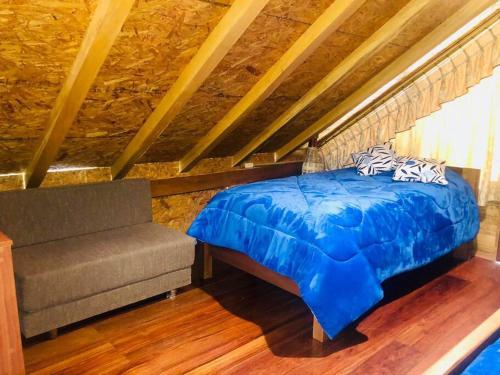 巴尼奥斯Hospedaje Puntzán的一间卧室配有蓝色的床和沙发