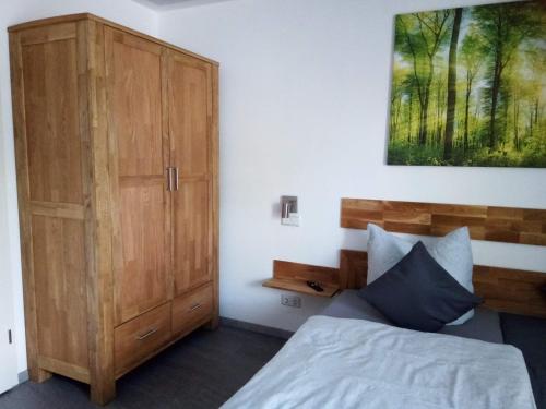 拉德博伊尔Kleines Nest的一间卧室配有一张床和一个木制橱柜