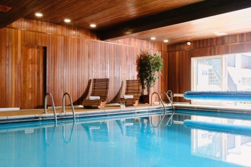 纽基凯布瑞尼酒店的一个带两把椅子的游泳池和一个游泳池