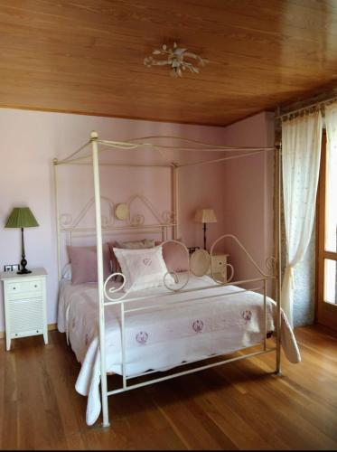 洛维奥斯Casa Rosalia的卧室配有白色的天蓬床和木制天花板