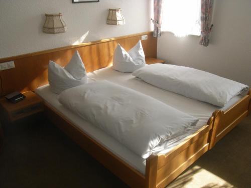 Schwabsberg金色拉姆宾馆的一间卧室配有两张带白色枕头的床