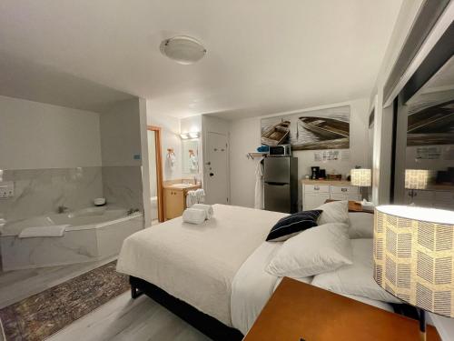 尤克卢利特Private Room On Waterfront Property With Hot Tub Firepit - Sea Esta的一间卧室设有一张大床和一个浴缸