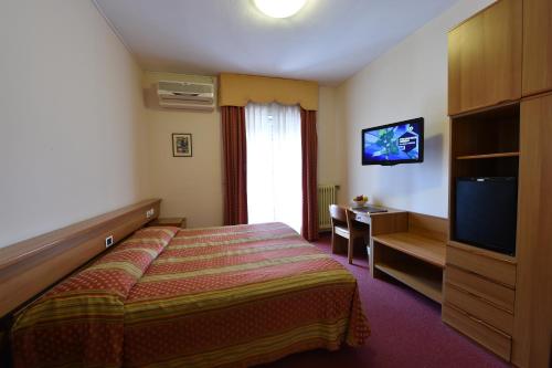 伊塞奥AMBRA HOTEL - The only central lakeside hotel in Iseo的酒店客房,配有床和电视