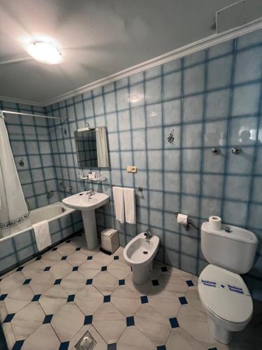 格罗韦Hotel Serantes的蓝色瓷砖浴室设有卫生间和水槽
