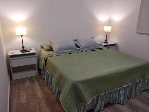 萨尔塔Cabañas Campo Quijano - Desértico的一间卧室配有一张床和两个带灯的床头柜