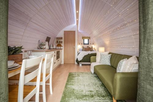 康威Tan Y Bryn Glamping的客厅配有绿色沙发和床。