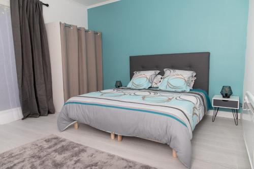 拉弗雷切Appartement 70m2 hyper centre avec baignoire balnéo的一间卧室配有一张带蓝色墙壁的大床