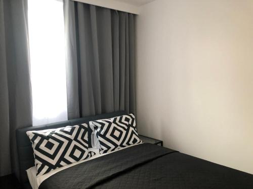 克拉科夫Apartamenty Platinex 6的一间卧室配有一张带枕头和窗户的床