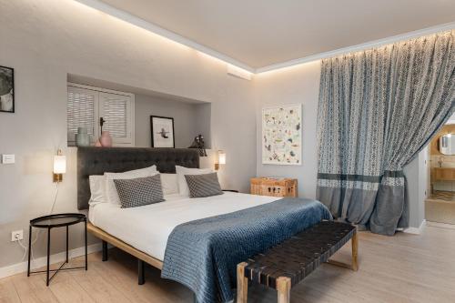 圣玛丽亚港Art Suites by Casa de Indias的一间卧室设有一张大床和一个窗户。