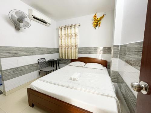 胡志明市Huy Hoàng Hotel的一间卧室配有一张床和一把椅子