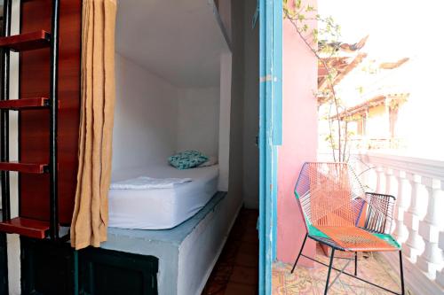 卡塔赫纳República Hostel Cartagena的带阳台的客房配有一张床和椅子