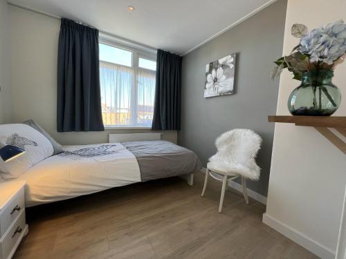 德科赫Duinzee Texel的一间卧室,配有一张床和花瓶