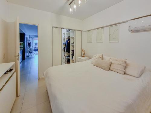 布宜诺斯艾利斯Departamento en Palermo Chico的一间白色卧室,配有一张大床和一个走廊