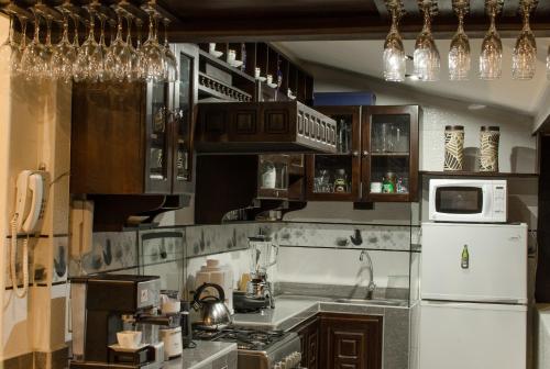 库斯科库斯科住宿加早餐旅馆的厨房配有木制橱柜和白色冰箱。
