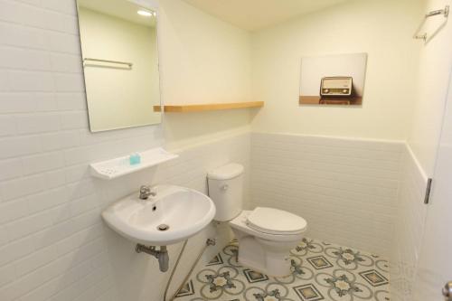 安帕瓦椰青园花园之家度假酒店的一间带卫生间、水槽和镜子的浴室
