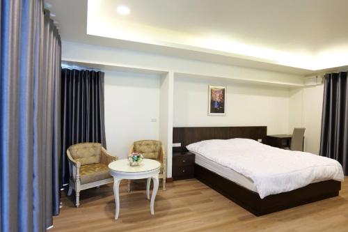 安帕瓦椰青园花园之家度假酒店的卧室配有一张床和一张桌子及椅子