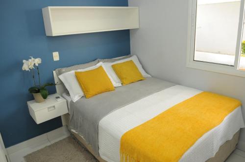 巴西利亚BIEN ÊTRE的一间卧室设有一张黄色和蓝色墙壁的床